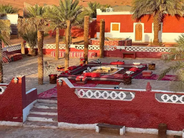 Patio d'un hôtel traditionnel rouge et blanc à Timimoun